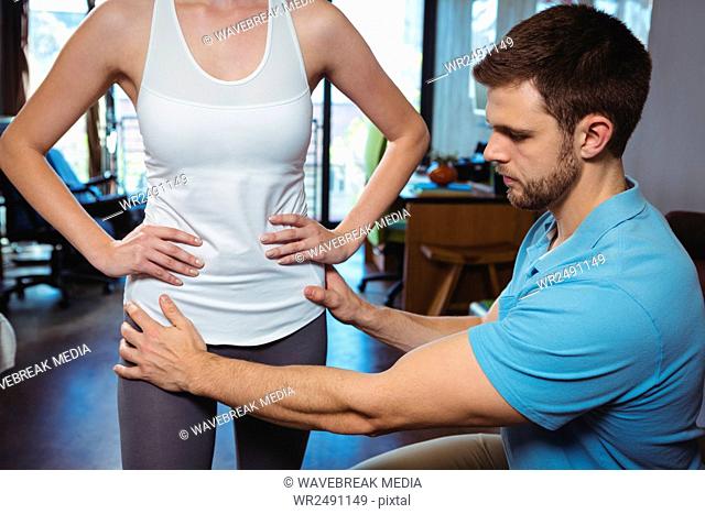 Physiotherapist correcting position of female patient