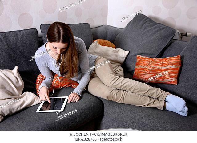 Girl playing at home with an iPad, tablet computer, wireless internet access