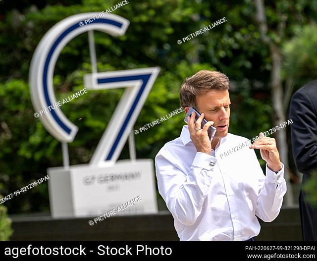 27 June 2022, Bavaria, Elmau: Emmanuel Macron, President of France, talks on the phone with the so-called ""outreach states"" during a break in the meeting at...