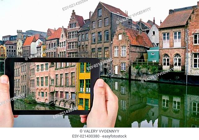 tourist taking photo of old houses in Ghent