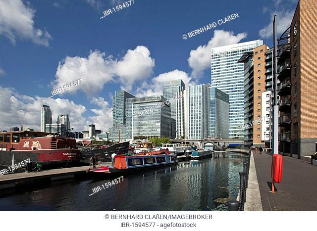House boat in the port, office buildings and residential houses in Canary Wharf, the new financial district of London in the Docklands