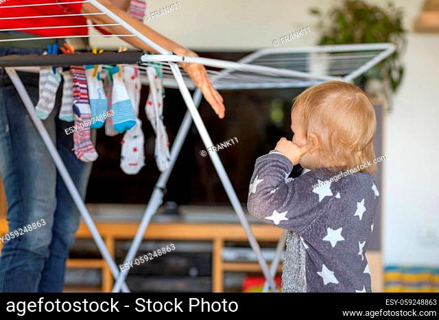 Cue little boy helps with hanging socks at home. Horizontally