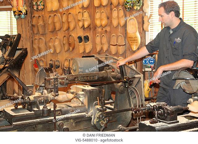 Craftsman using a machine to make traditional Dutch wooden shoes in the small town of Zaanse Schans, Holland, Netherlands, Europe