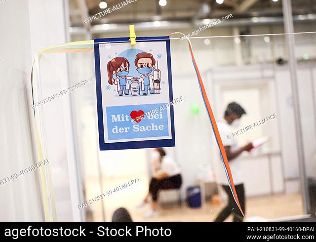 31 August 2021, Hamburg: A card with the text ""With heart in the matter"" hangs on a registration desk on the last day of opening at the vaccination center in...