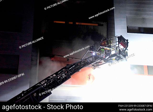 08 December 2023, Baden-Württemberg, Heddesheim: Firefighters extinguish a fire in an apartment building. Two residents were injured in a fire in an apartment...