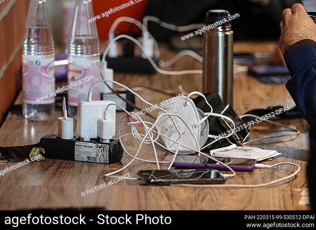 15 March 2022, Hessen, Alsfeld: Several cell phones hang from charging cables. Everyday life in the emergency shelter for refugees from Ukraine in the...