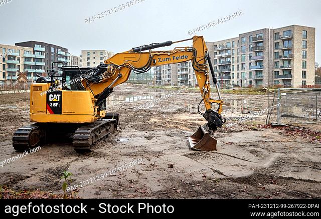 12 December 2023, Hamburg: View of new buildings behind an excavator on a construction site in Eidelstedt. The Department for Urban Development and Housing...