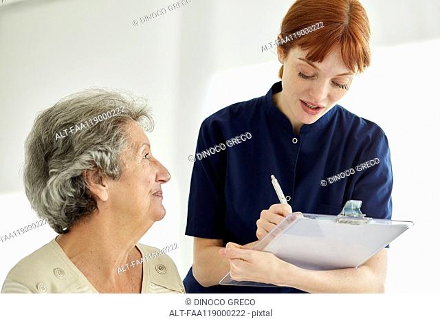 Nurse writing medical history of patient
