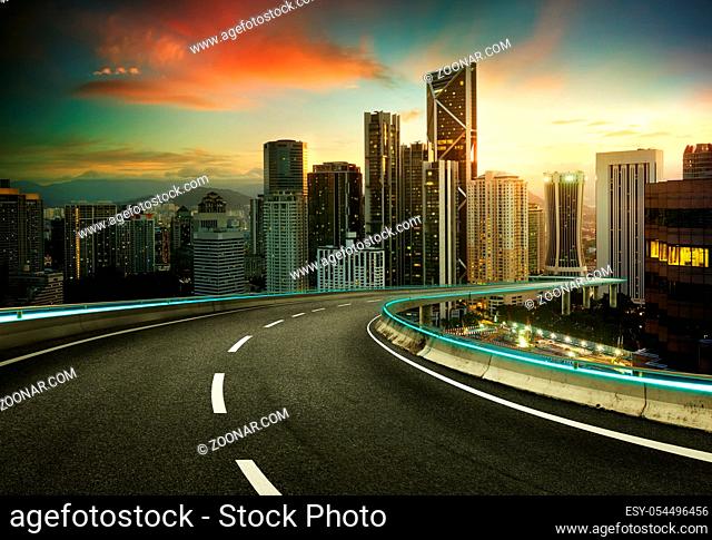 Blue neon light design highway overpass with modern city background .Early morning scene