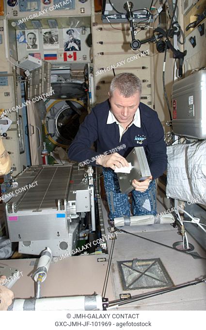Russian cosmonaut Oleg Novitskiy, Expedition 34 flight engineer, performs routine in-flight maintenance on the Treadmill Vibration Isolation System (TVIS) in...