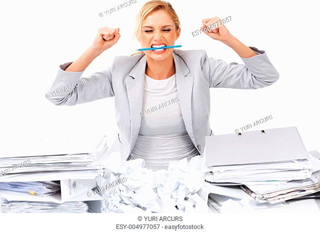 A frustrated businesswoman crushing a pencil between her teeth and clenching her fists angrily
