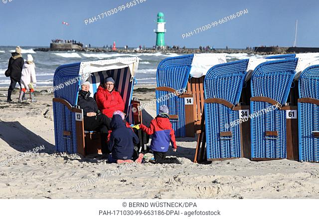 After the heavy autumn storm 'Herwart' beach visitors enjoy the sun at the Baltic Sea beach in Warnemuende, Germany, 30 October 2017