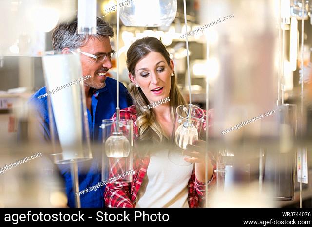 Couple, woman and man, woman and man, in electrical goods department of hardware store looking for lamps