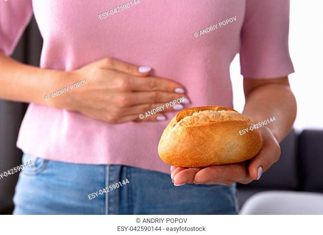 Midsection View Of A Woman Suffering From Stomach Pain Holding Bread