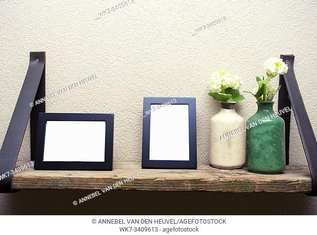 Two blank picture frames with decoration flowers on wood shelf industrial design space for text