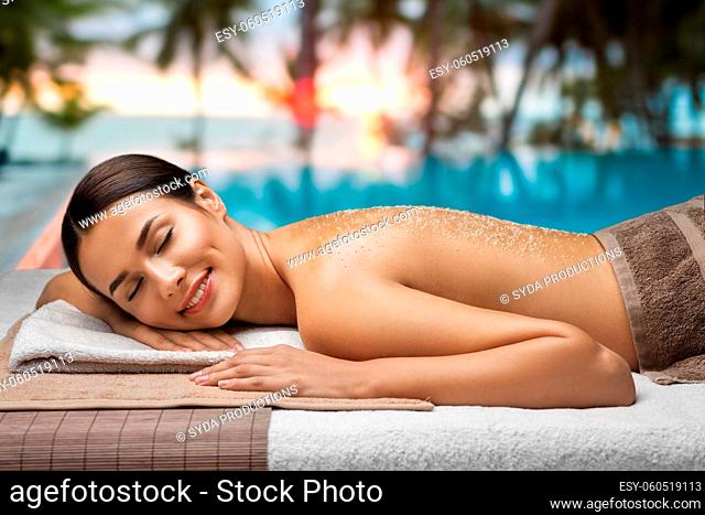 woman lying with sea salt on skin at spa