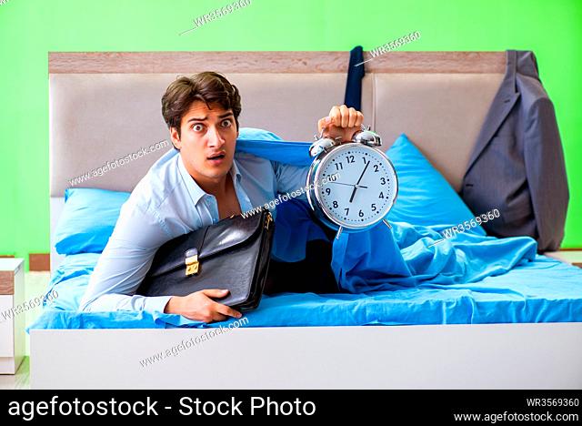 Employee in the bedroom being late for his job in time management concept