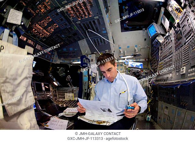 Astronaut Christopher Cassidy, STS-127 mission specialist, looks over a checklist during a training session in the Jake Garn Simulation and Training Facility at...