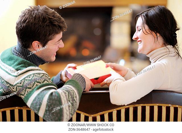 happy Young romantic couple and relaxing sofa in front of fireplace at winter season in home
