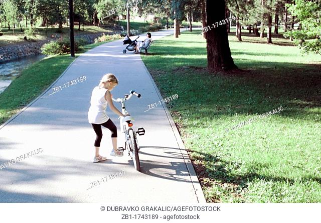 Small girl with bike in the park