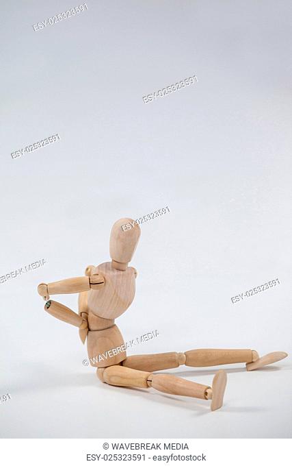 Wooden figurine sitting with hands on back