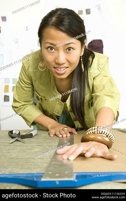 Asian female fashion designer using t-square