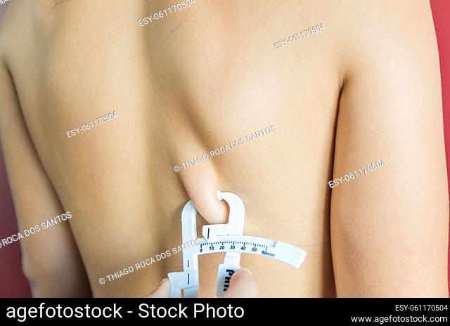 Measuring a woman's body fat using an adipometer
