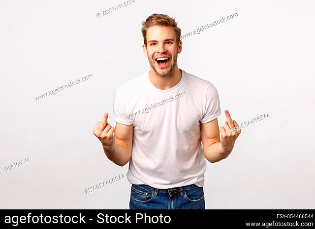 Rude and expressive, intollerant blond happy careless guy, dont care people opinion, fuck-off, showing middle fingers and cursing with smile on face