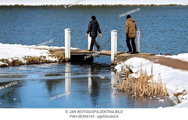 People cross a bridge in the park of Woerlitz, Germany, 24 March 2013. Despite the wintery weather the new season 2013 will be opened at the Dessau-Woerlitz...