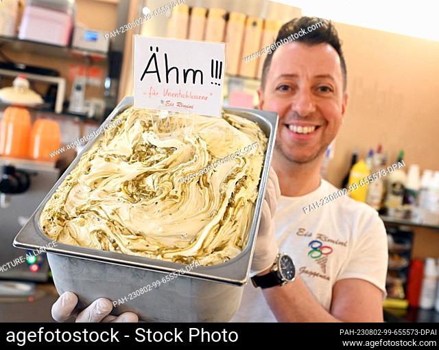 PRODUCTION - 29 July 2023, Baden-Württemberg, Gaggenau: Alessandro Cimino shows off an ""um"" ice cream at his Rimini ice cream parlor
