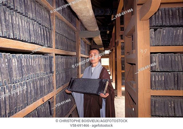 Buddhist monk presentinf one of the 80000 wooden blocks on which are carved the complete Buddhist scriptures of 'Tripitaka', Haein-sa monastery