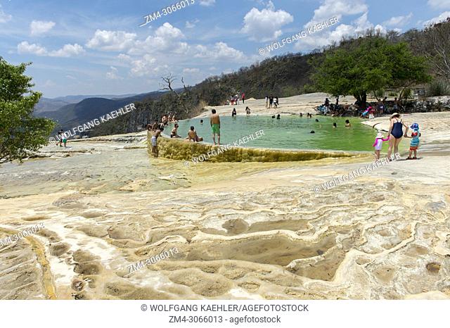 People bathing in the artificial pool filled with water from fresh water springs, whose water is over-saturated with calcium carbonate and other minerals at...
