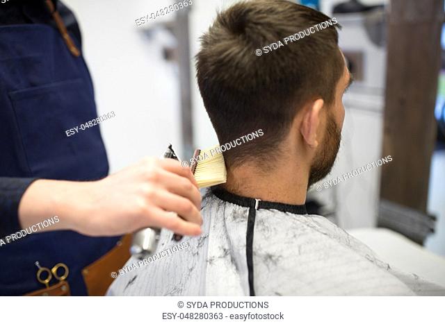 male client and barber cleaning hair from neck