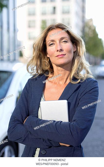 Portrait of confident businesswoman holding tablet in the city