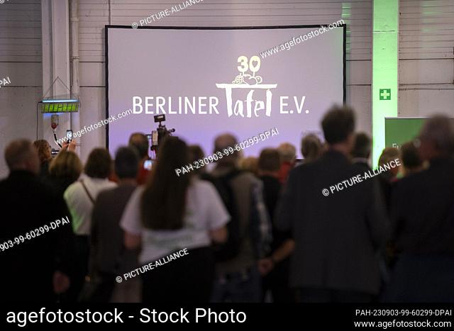 03 September 2023, Berlin: Numerous guests celebrated the 30th anniversary of the Berliner Tafel, while the logo of the Berliner Tafel is displayed on a wall