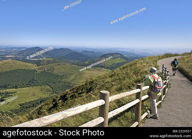 Hiker with view from Puy de Dome onto the volcanic landscape of the Chaine des Puys, Auvergne, France, Europe