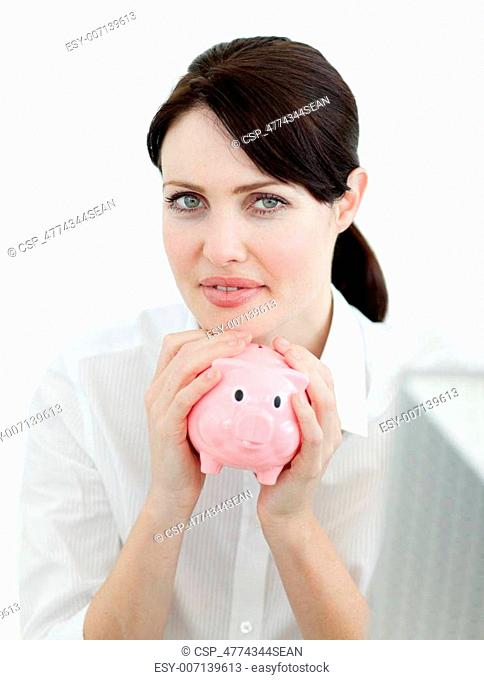 Serious businesswoman holding a piggybank