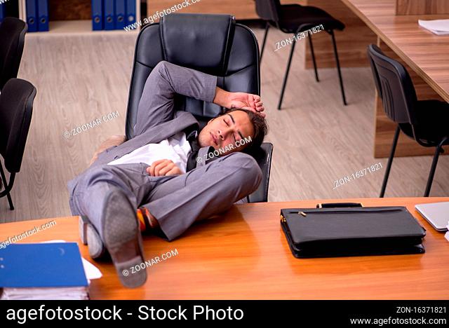Young employee sleeping at workplace