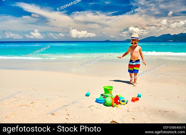 Three year old toddler boy playing with beach toys on beach. Summer family vacation at Seychelles, Mahe