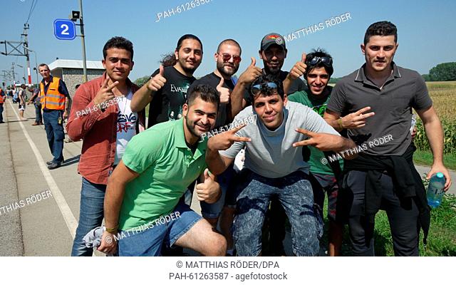 Eight young men from Syria and Irak are happy and pose at the train station in Nickelsdorf, Austria, 1 September 2015. They look forward to travel to Vienna and...