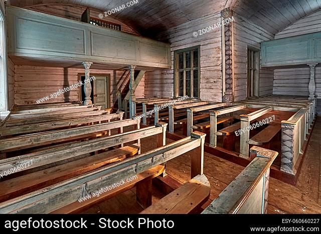 Old wooden church interior wtih rows of benches