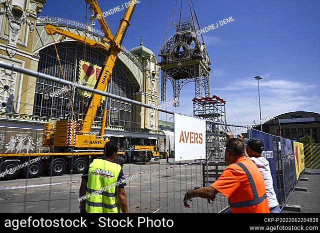 Workers with the help of cranes bring down the clock tower from the roof of the reconstructed Industrial Palace at the Prague Exhibition Grounds, on June 22