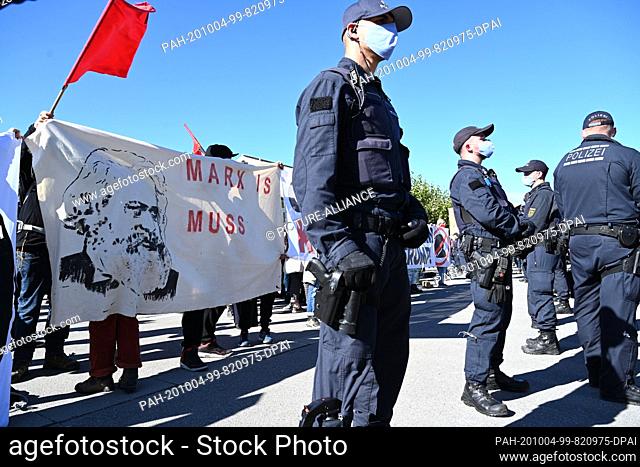 04 October 2020, Baden-Wuerttemberg, Konstanz: Counter-demonstrators hold a banner with the inscription ""Marx is Muss"" and a picture of the German philosopher...