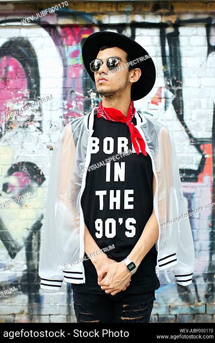 Fashionable young man with hat and sunglasses wearing t-shirt with saying 'Born in the 90s'