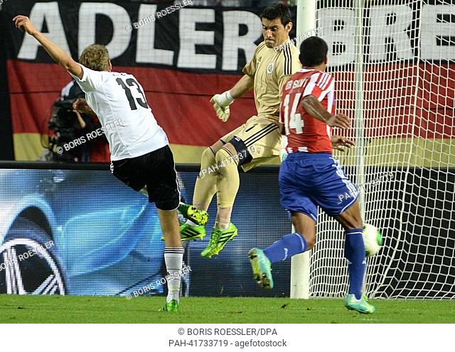 Germany's Thomas Mueller (L) scores for the 2:2 against Paraguay's goalkeeper Justo Villar during the international friendly soccer match between Germany vs...