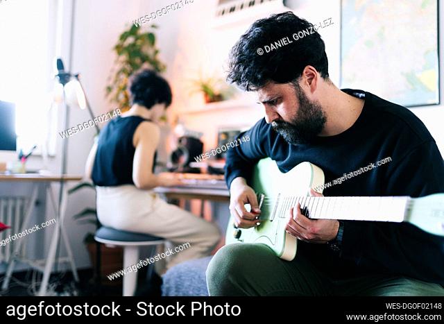 Male musician playing guitar in studio