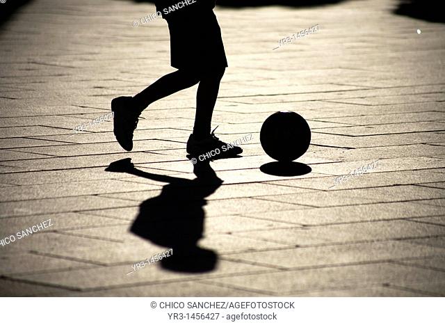 A boy plays soccer in the main square of Merida, Badajoz province, Extremadura region