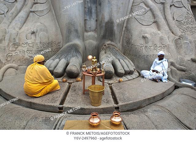 A jaïn pilgrim is praying near the feet of a statue representing Gomateshwara at Sravanabelagola ( Karnataka, India). Gomateshwara is one of the name of the...