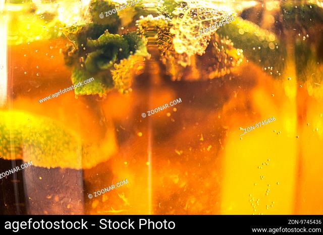 Carbonated soda water or juice with lime and mint in a glass jug. Macro closeup