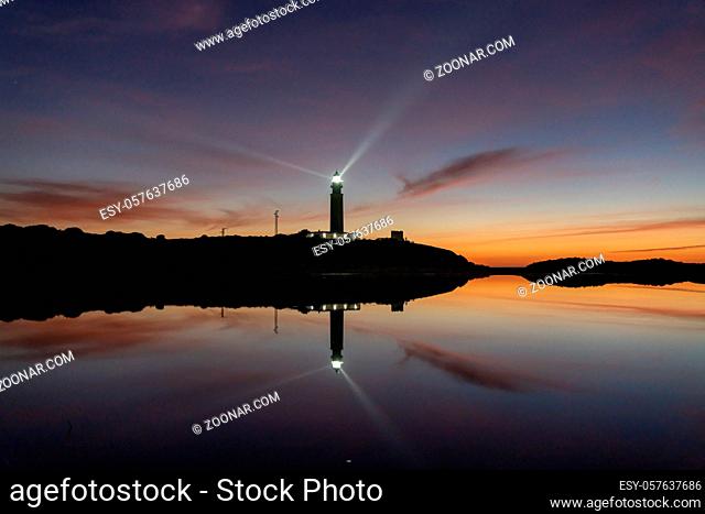 A view of the Cape Trafalgar lighthouse signal light after sunset with colorful evening sky